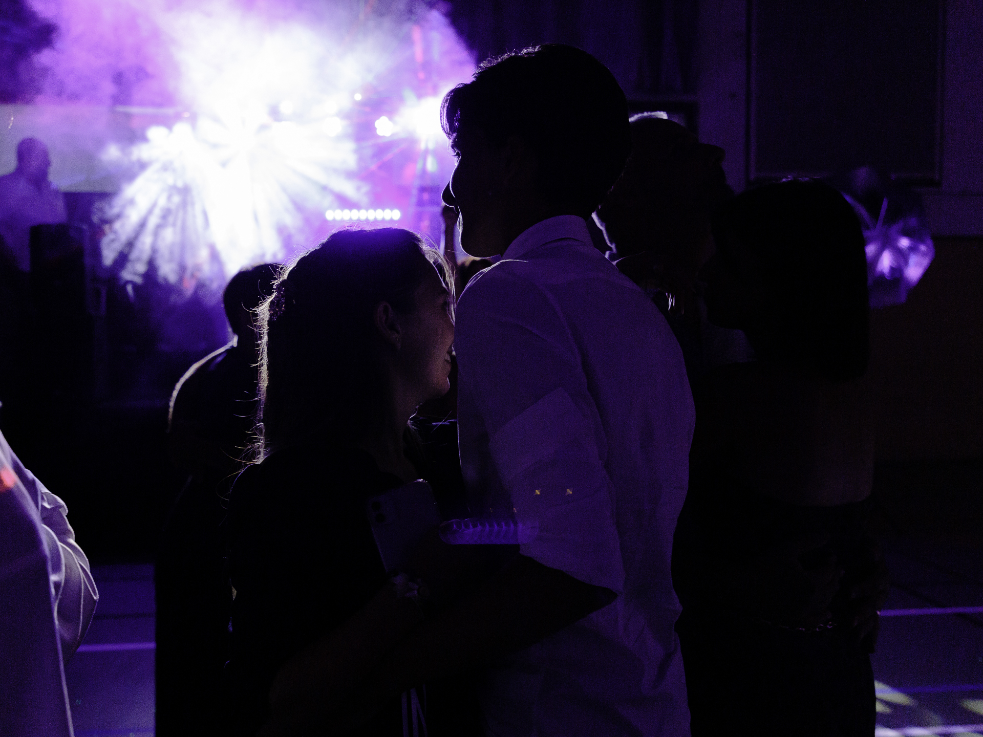 Photos des invités dansant sur la piste, éclairés par les lumières du dj. Photo prise lors de la soirée de mariage.